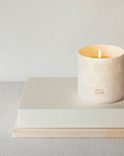 Photo of white isle de nature candle on top of a beige book