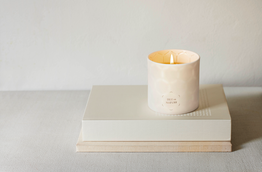 Photo of white isle de nature candle on top of a beige book